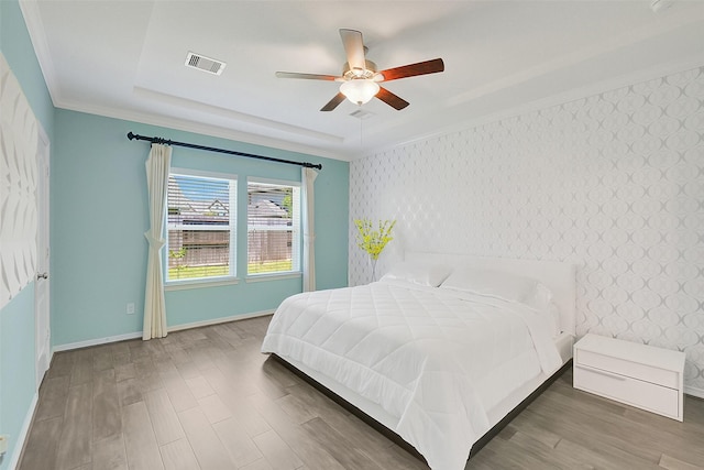 6323 Grand Summit Ct, Katy, TX 77494 - bedroom with baseboards, wood finished floors, an accent wall, crown molding, and wallpapered walls