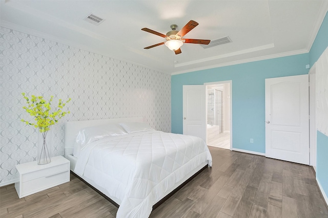 6323 Grand Summit Ct, Katy, TX 77494 - bedroom with crown molding, wood finished floors, wallpapered walls, connected bathroom, and an accent wall