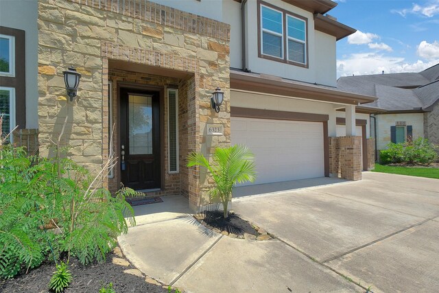 6323 Grand Summit Ct, Katy, TX 77494 - property entrance with concrete driveway, an attached garage, stone siding, and brick siding