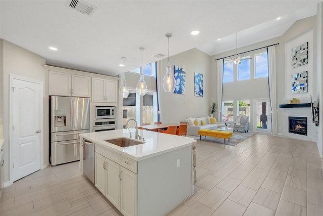 6323 Grand Summit Ct, Katy, TX 77494 - kitchen with appliances with stainless steel finishes, a sink, light countertops, open floor plan, and an island with sink