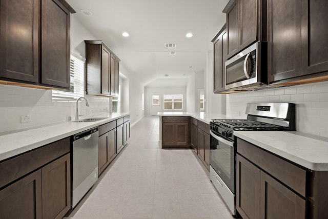 666 Cherry Tree Dr, La Marque, TX 77568 - kitchen with appliances with stainless steel finishes, a sink, dark brown cabinets, backsplash, and recessed lighting