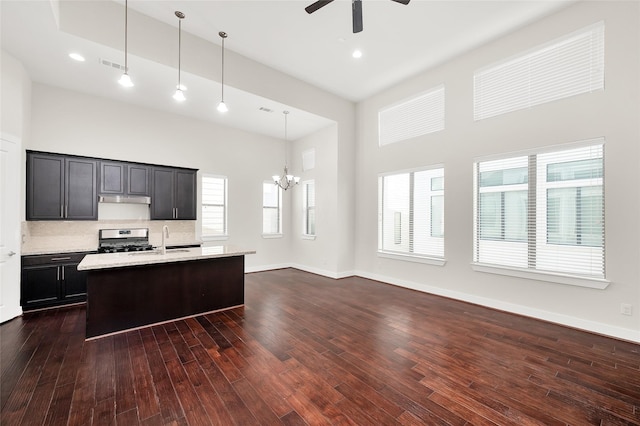 34 N Hutcheson St, Houston, TX 77003 - kitchen with stainless steel range with gas stovetop, a sink, a towering ceiling, under cabinet range hood, and a chandelier