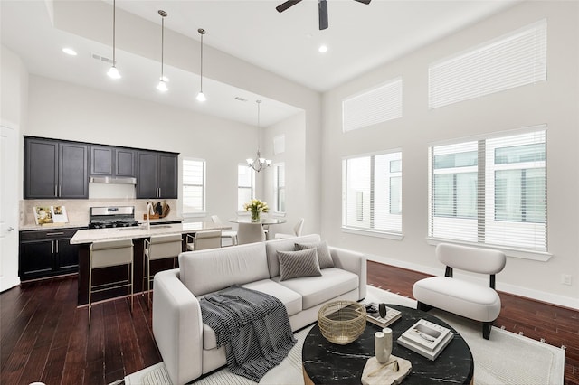 34 N Hutcheson St, Houston, TX 77003 - living room featuring a towering ceiling, dark wood finished floors, a ceiling fan, a chandelier, and baseboards