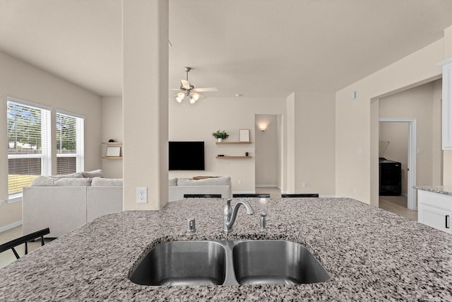 635 W Linnwood Dr, Woodbranch, TX 77357 - kitchen with a sink, open floor plan, light stone counters, a ceiling fan, and white cabinets