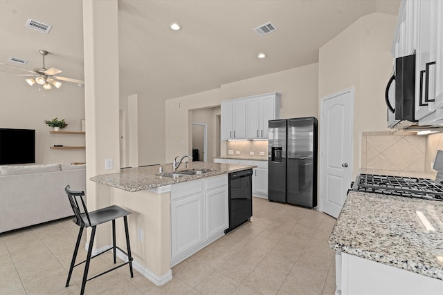 635 W Linnwood Dr, Woodbranch, TX 77357 - kitchen with stainless steel appliances, a sink, decorative backsplash, light tile patterned floors, and light stone counters
