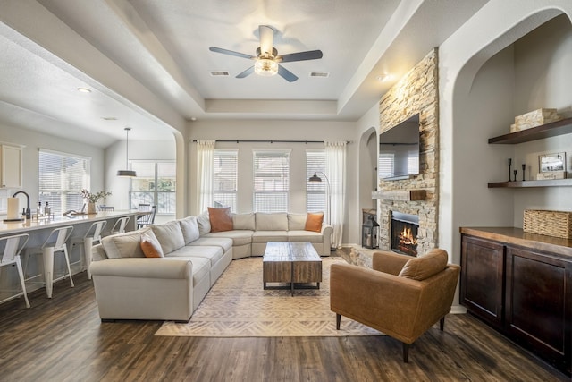123 Clearmont Pl, Montgomery, TX 77316 - living area with ceiling fan, a stone fireplace, dark wood-type flooring, and a tray ceiling