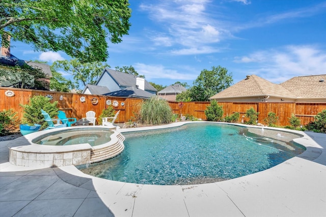 view of pool with a fenced backyard, a pool with connected hot tub, and a patio area