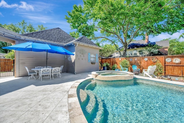 view of swimming pool featuring fence, a patio, and a pool with connected hot tub