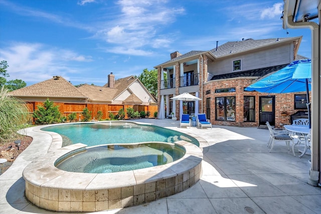 view of pool featuring a patio, a fenced backyard, and a pool with connected hot tub