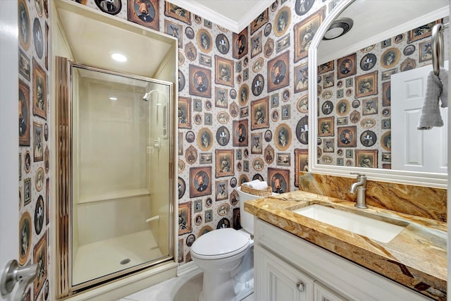 bathroom with wallpapered walls, crown molding, a stall shower, toilet, and vanity
