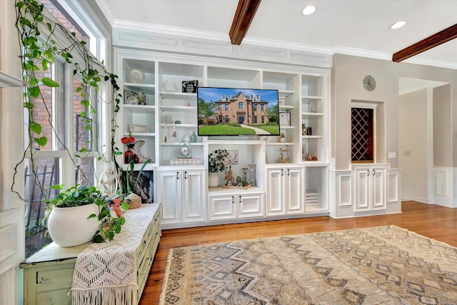 living room featuring crown molding, light wood-style floors, and beam ceiling