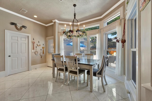 dining area with a chandelier, a textured ceiling, light tile patterned flooring, crown molding, and baseboards