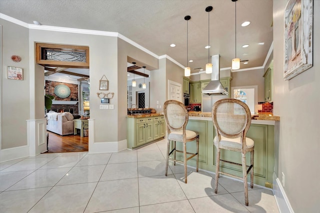 kitchen featuring island exhaust hood, green cabinetry, a breakfast bar, a sink, and stainless steel oven
