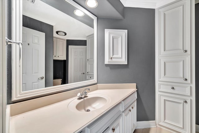 bathroom with vanity, baseboards, toilet, and tile patterned flooring