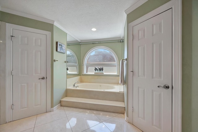 bathroom with ornamental molding, tile patterned floors, a bath, a textured ceiling, and baseboards