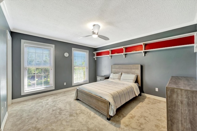 carpeted bedroom with baseboards, a textured ceiling, ceiling fan, and crown molding