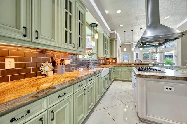 kitchen with green cabinets, stainless steel gas stovetop, island exhaust hood, a peninsula, and recessed lighting