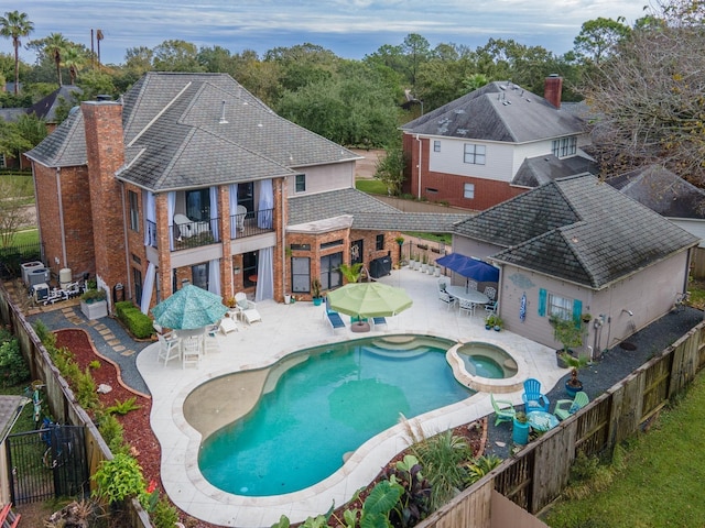 view of pool with a fenced backyard, a patio, outdoor dining space, and a pool with connected hot tub
