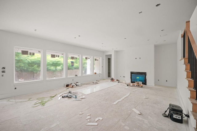 5223 Mimosa Dr, Bellaire, TX 77401 - unfurnished living room featuring a glass covered fireplace and stairway