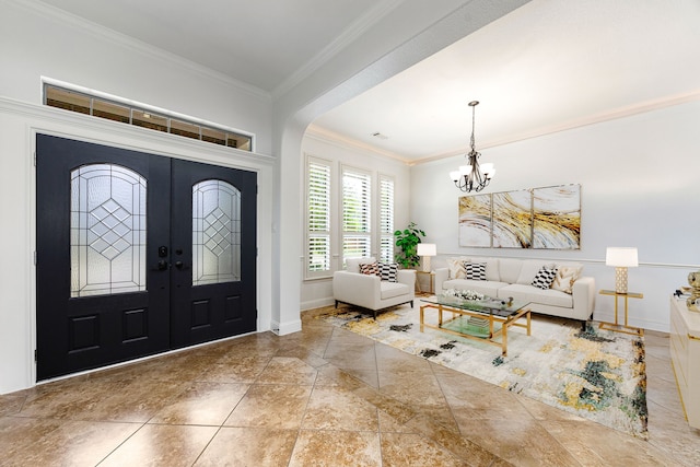 foyer entrance featuring crown molding, a chandelier, baseboards, french doors, and arched walkways