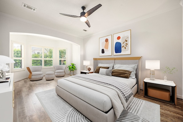 bedroom featuring crown molding, wood finished floors, a ceiling fan, and baseboards
