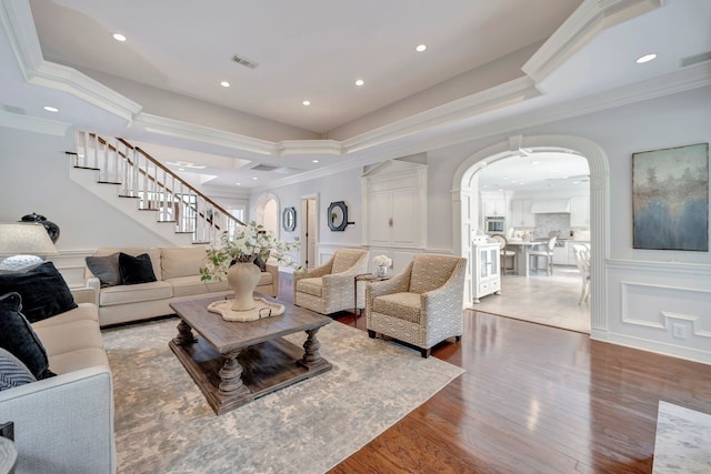 206 Greenbriar Ave, Friendswood, TX 77546 - living room featuring crown molding, stairs, arched walkways, recessed lighting, and wood finished floors