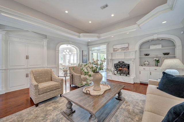 206 Greenbriar Ave, Friendswood, TX 77546 - living room featuring a chandelier, dark wood-type flooring, a premium fireplace, ornamental molding, and arched walkways