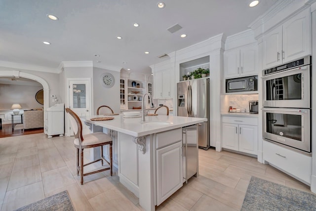 206 Greenbriar Ave, Friendswood, TX 77546 - kitchen with stainless steel appliances, a sink, white cabinets, recessed lighting, and a kitchen island with sink