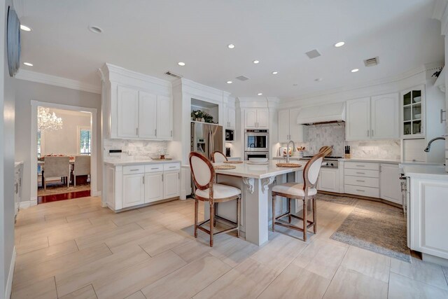 206 Greenbriar Ave, Friendswood, TX 77546 - kitchen featuring custom exhaust hood, a breakfast bar, decorative backsplash, white cabinetry, and ornamental molding