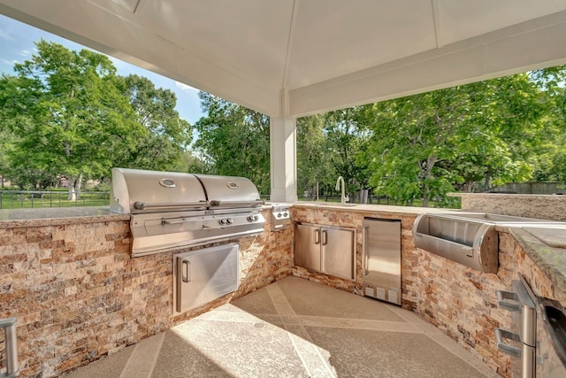 206 Greenbriar Ave, Friendswood, TX 77546 - view of patio / terrace featuring a grill, an outdoor kitchen, fence, a sink, and view of scattered trees