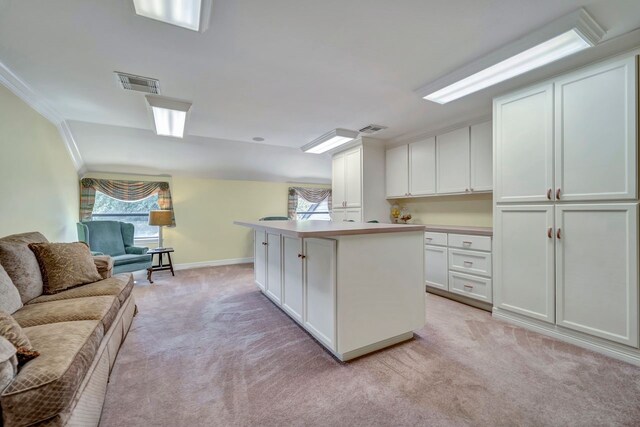 206 Greenbriar Ave, Friendswood, TX 77546 - kitchen with light carpet, open floor plan, baseboards, white cabinetry, and light countertops
