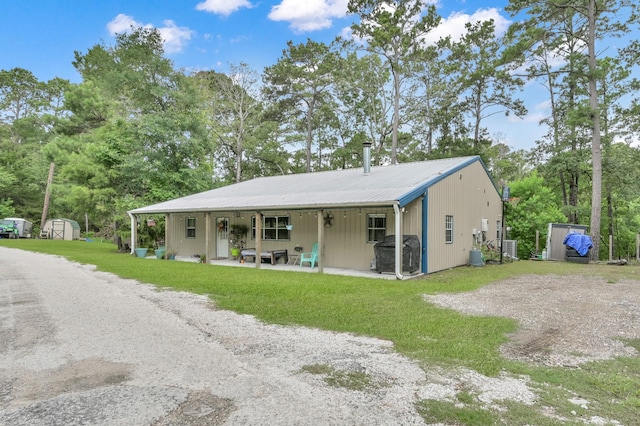 315 Cessna Rd, Trinity, TX 75862 - view of front facade featuring a front yard, metal roof, and view of scattered trees