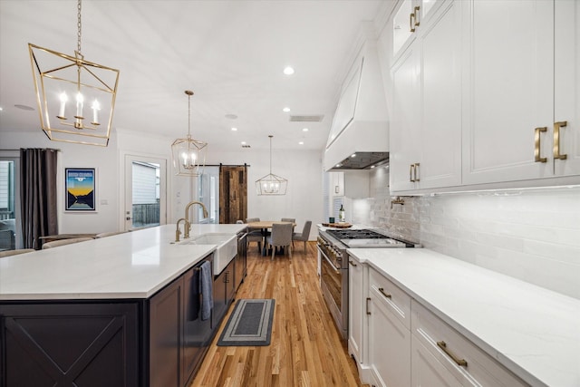 319 E 26th St, Houston, TX 77008 - kitchen featuring a sink, stainless steel range, a chandelier, light wood finished floors, and white cabinets