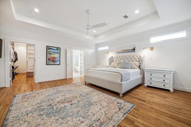319 E 26th St, Houston, TX 77008 - bedroom with a tray ceiling, wood finished floors, recessed lighting, baseboards, and a spacious closet