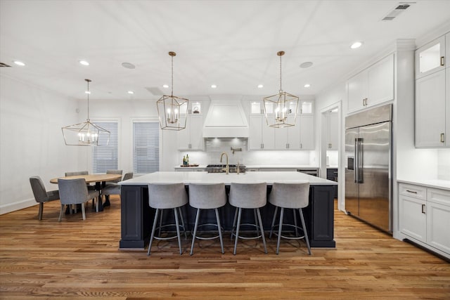319 E 26th St, Houston, TX 77008 - kitchen with built in refrigerator, custom range hood, a chandelier, light wood-style floors, and recessed lighting