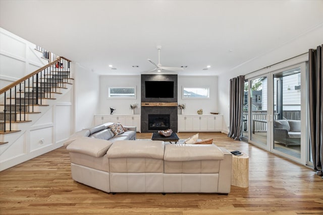319 E 26th St, Houston, TX 77008 - living area featuring ceiling fan, light wood-style flooring, a tiled fireplace, stairs, and recessed lighting