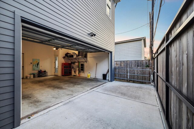 319 E 26th St, Houston, TX 77008 - garage at dusk featuring fence and concrete driveway
