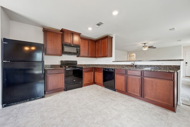6023 Treasure Cove Rd, Cove, TX 77523 - kitchen with black appliances, a peninsula, dark stone counters, ceiling fan, and a sink