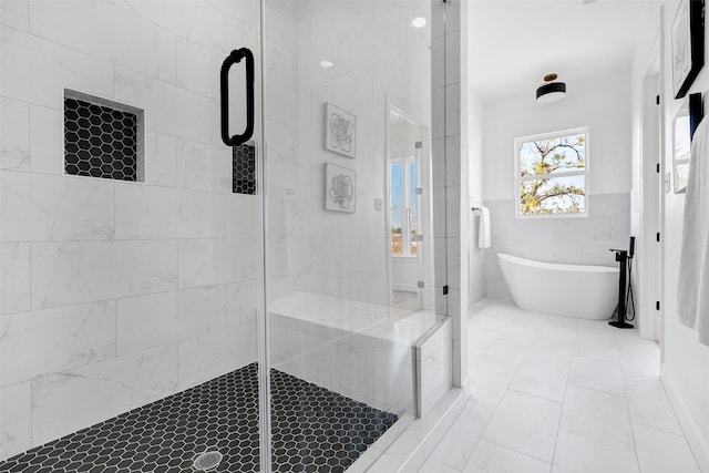 bathroom featuring a freestanding tub, a shower stall, and tile walls