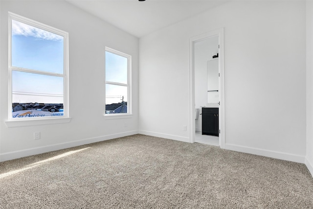 unfurnished living room featuring carpet flooring and baseboards