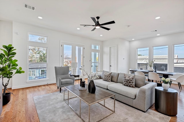 living room featuring healthy amount of natural light, recessed lighting, light wood finished floors, a ceiling fan, and baseboards
