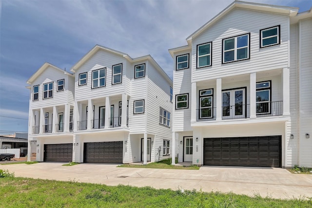 view of front facade featuring an attached garage, a balcony, and driveway