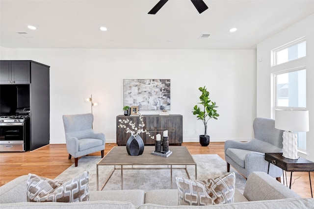 living room featuring a ceiling fan, light wood-type flooring, recessed lighting, and baseboards