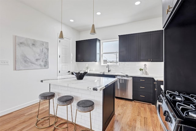 kitchen featuring stainless steel appliances, decorative backsplash, light wood-style floors, a kitchen breakfast bar, and light stone counters