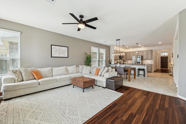 living area with a ceiling fan, light wood-type flooring, recessed lighting, and baseboards