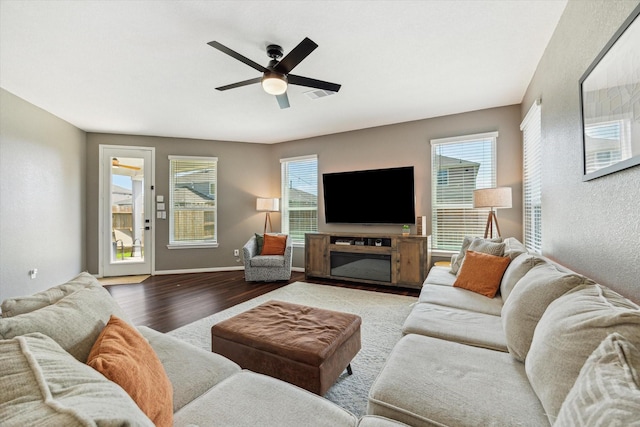 living area featuring wood finished floors, ceiling fan, and baseboards