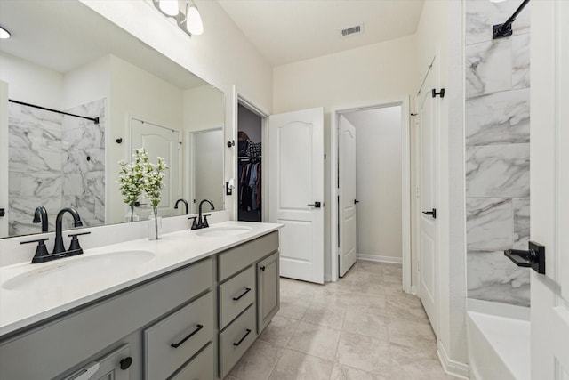 bathroom featuring a shower, a spacious closet, and double vanity