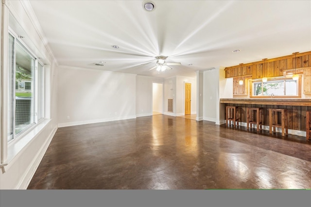 13016 W Burton St, Burton, TX 77835 - unfurnished living room featuring baseboards, crown molding, finished concrete flooring, a sink, and ceiling fan