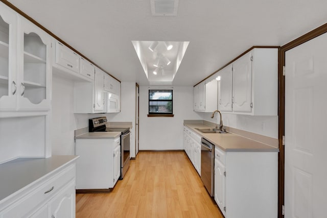132 Prairie View Ln, Red Oak, TX 75154 - kitchen with a sink, appliances with stainless steel finishes, white cabinetry, light wood-style flooring, and light countertops