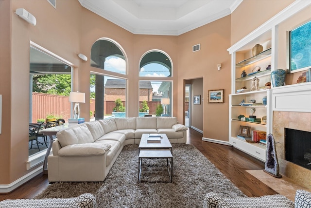 5206 Stamper Way, Houston, TX 77056 - living area with a tile fireplace, wood finished floors, built in shelves, baseboards, and a towering ceiling